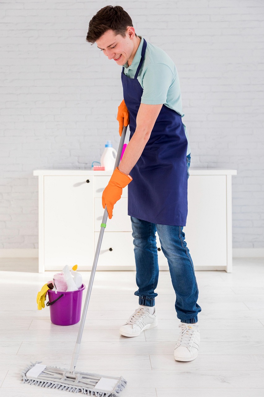 A man mopping the floor with cleaning supplies in a bucket behind him,  Image by Prime Ace Support from Pixabay